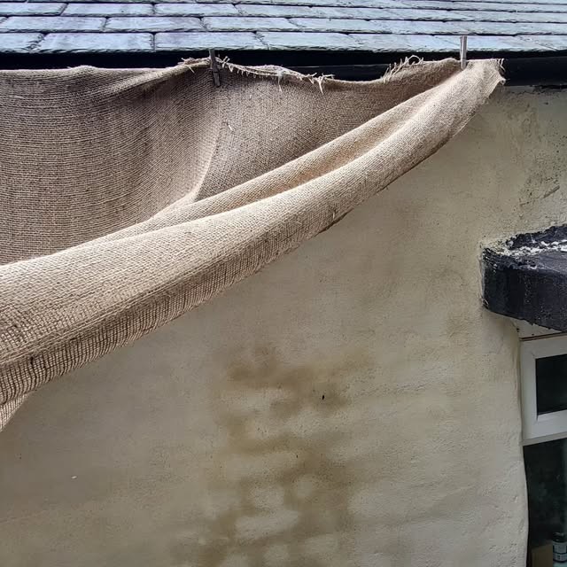 Hessian protecting newly rendered exterior wall