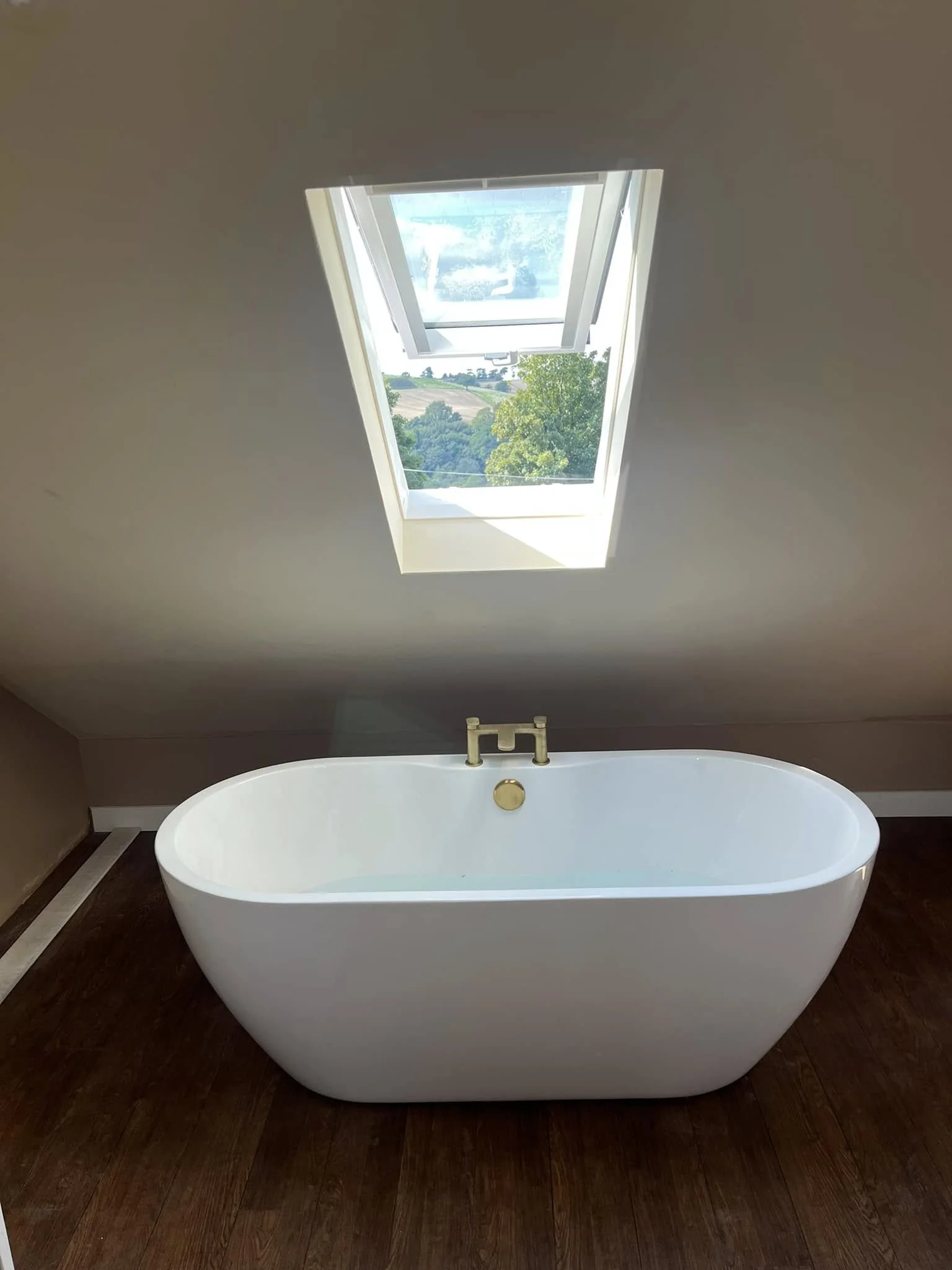 Freestanding bath below a roof window
