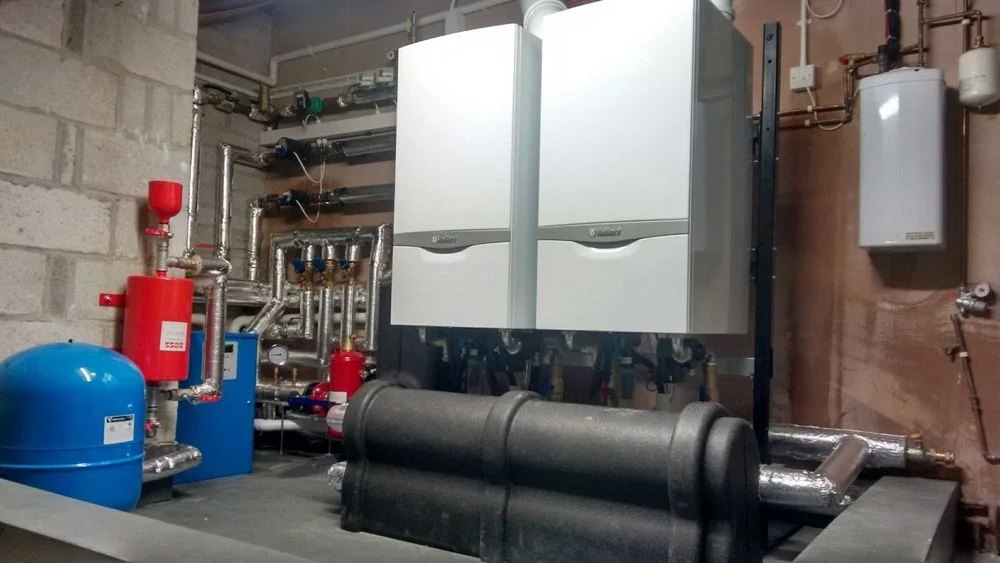 Twin wall-mounted boilers and heating system pipework by Scott Plumbing and Heating